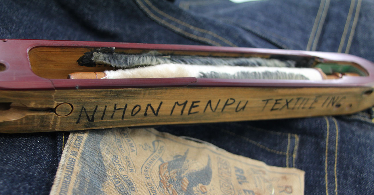 日本綿布のデニムと、伝統的なシャトル織機に使われるシャトルの画像